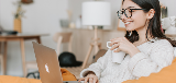 Woman Drinking Coffee on Laptop