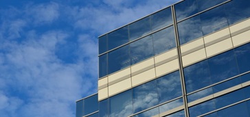 glass building with clouds