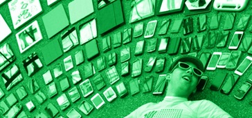 person laying on ground surrounded by smart devices green tint