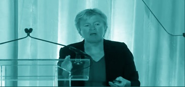 woman speaking at a conference, blue-green tint