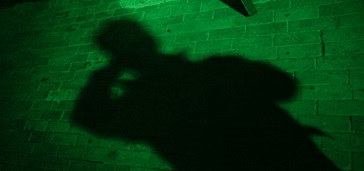 shadow of person using mobile phone, green tint