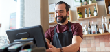 Man in apron at cash register