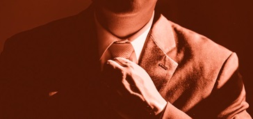 neck and shoulders of a man adjusting his tie, red tint